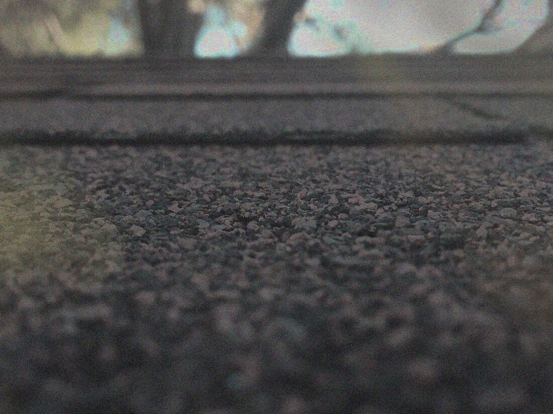 Faded, weathered shingle field worn down by years of Oklahoma weather