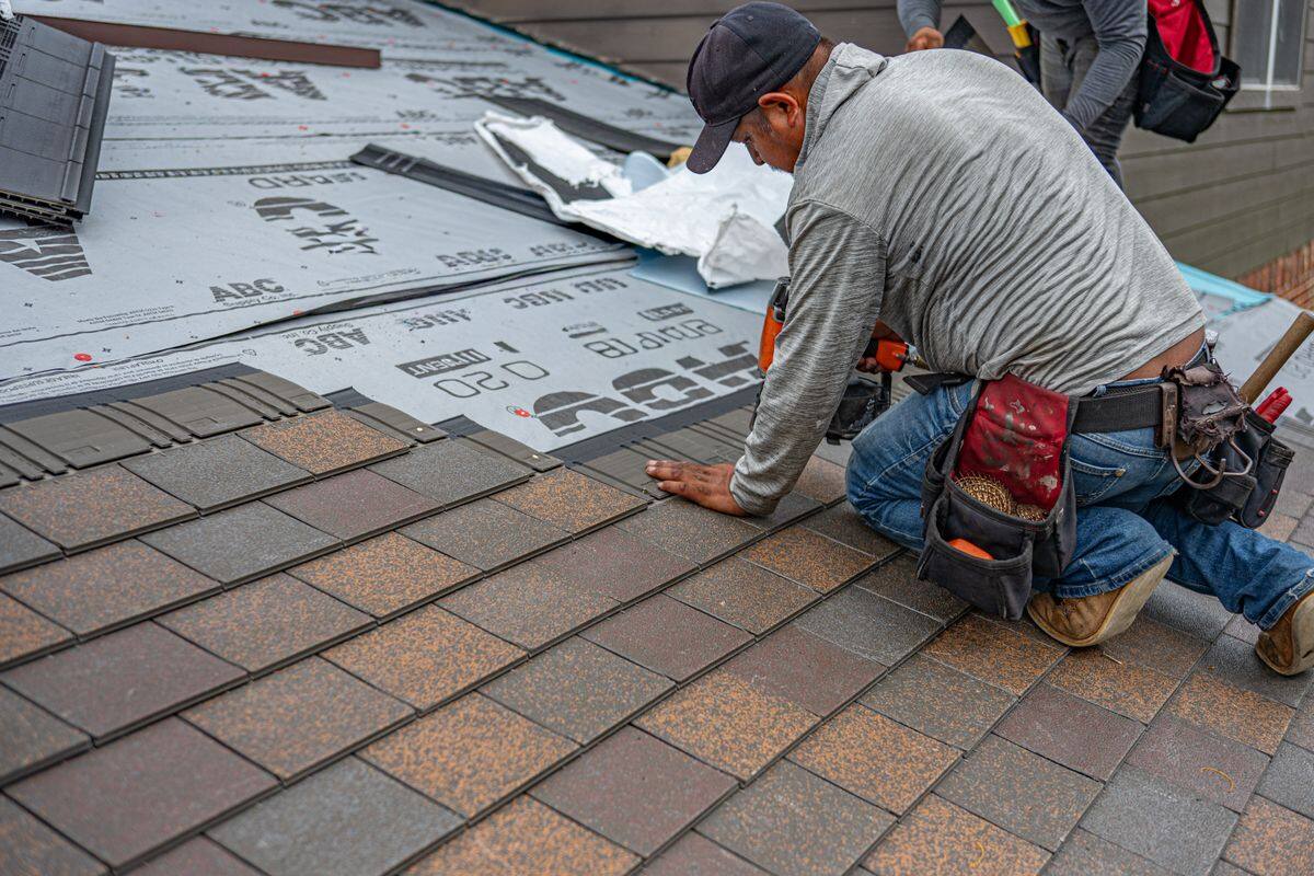 Farnsworth Quality Roofing installer laying architectural shingles over fresh underlayment